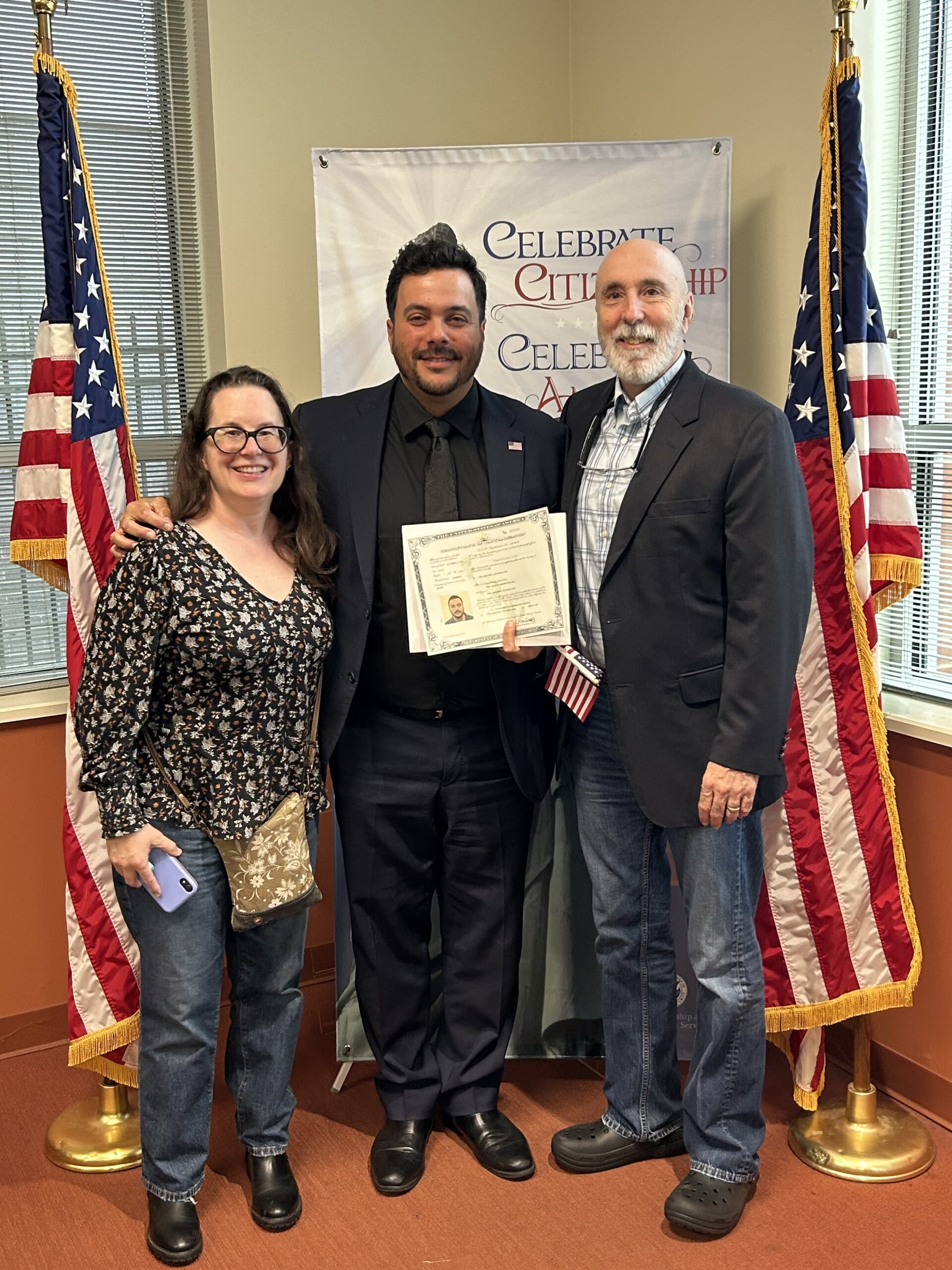 A man and his friends smiling together after a naturalization ceremony.