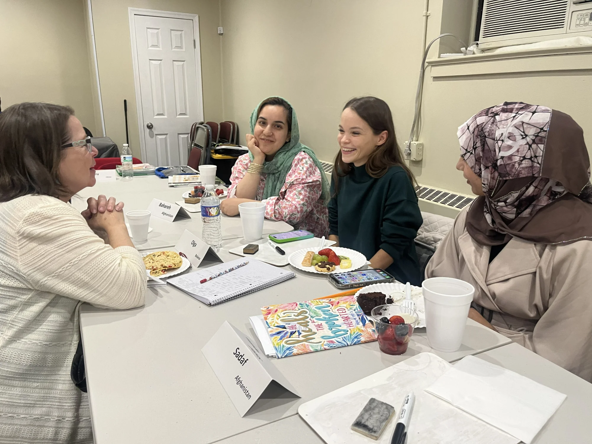A group of ladies sitting around a table talking with one another during a conversation cafe event at GROW.